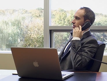 man in suit on phone at a desk