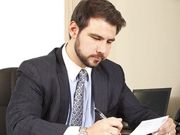 man in suit signing papers